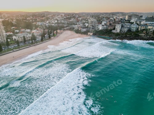 Preview: Aerial drone view of beautiful Manly Beach with foamy waves rolling and crashing at sunset