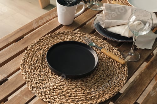 Preview: empty black plate on decorated wooden table