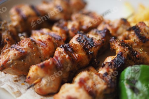 Preview: Grilled chicken kebabs served on a plate with vegetables