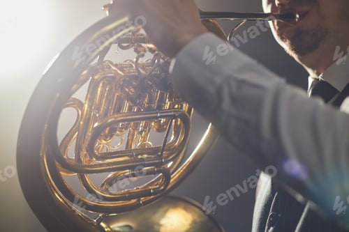 Preview: Shiny Metal Tubes of French Horn on Hands of Musician Playing Jazz on Stage