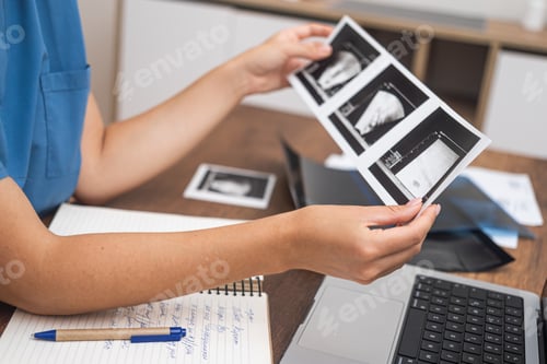 Preview: doctor interprets ultrasound results, making notes on her laptop for detailed documentation.