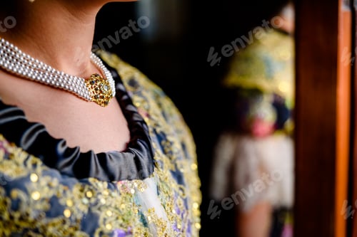 Preview: Detail of a pretty woman dressed in the traditional Valencian Fallera dress with her neck decorated