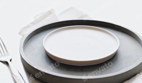 Preview: empty grey plates on a table with fork and knife. spring menu concept. trendy nordic minimal style