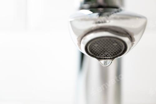 Preview: Close-up water drop from the tap with copy space, horizontal. Detail modern bathroom, lifestyle