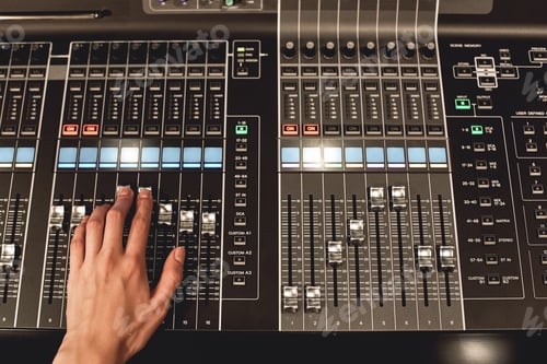 Preview: Professional sound control. Close-up view of male hand mixing sounds on digital audio mixing console