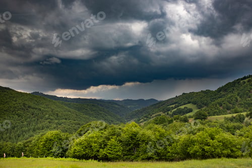 Preview: Storm clouds above meadow with green grass