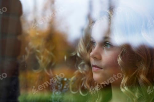 Preview: Girl with long blond hair gazing through window
