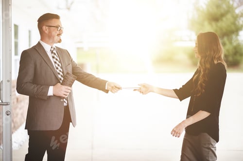 Preview: Male and female church members exchanging notes at church doors with bright sunlight in background