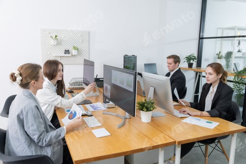 Preview: Four colleagues working in a modern office with computers