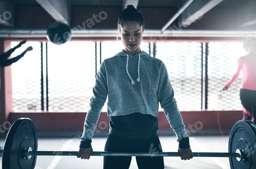 Preview: Fit healthy woman lifting a weight barbell