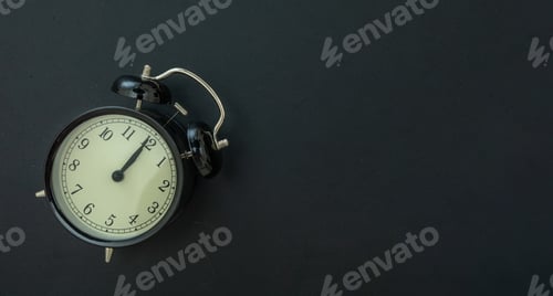 Preview: Black alarm clock on dark background copy space, overhead.