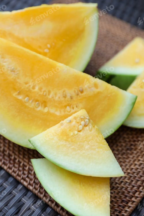 Preview: Pieces of ripe yellow watermelon on wicker table, closeup