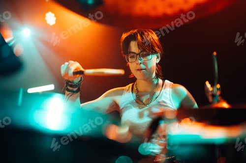 Preview: Drummer playing with drumsticks on illuminated stage