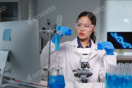Preview: Scientist pouring blue chemical liquid in beaker for research in laboratory