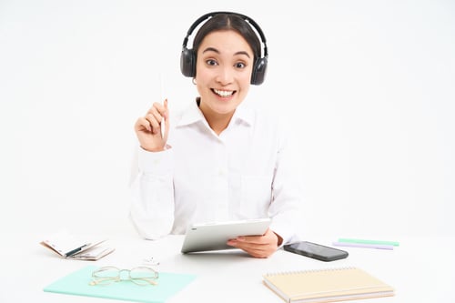 Preview: Portrait of professional woman working, listening podcast or course in headphones, holding digital