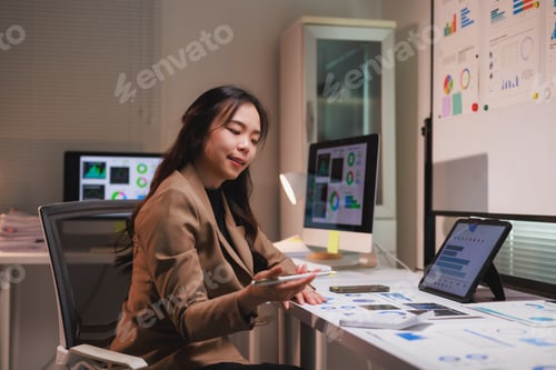 Preview: Asian businesswoman analyzing data and financial reports at desk