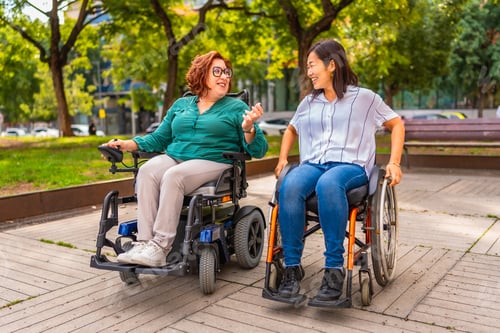 Preview: Happy women friends with disability talking in a park