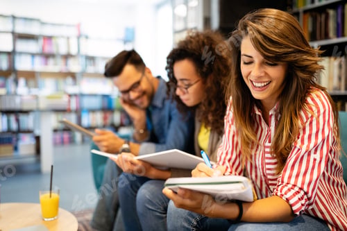 Preview: University students in cooperation at library. Group of young friends reading books