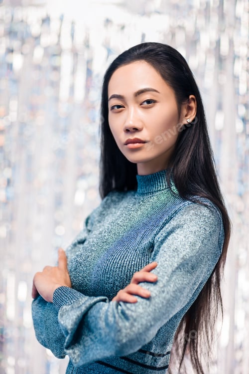 Preview: Confident asian woman in blue dress with crossed arms
