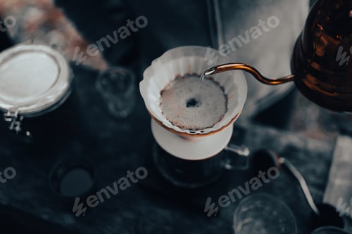 Preview: Men barista making a drip coffee, pouring hot water from kettle over a ground coffee powder