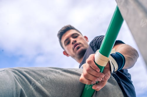 Preview: Vertical shot of a handsome sportsman in a park during training