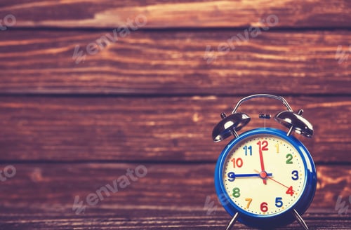 Preview: Retro alarm clock on a table. Photo in retro color image style