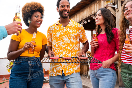 Preview: Multiethnic group of friends having dinner barbecue party on rooftop at home