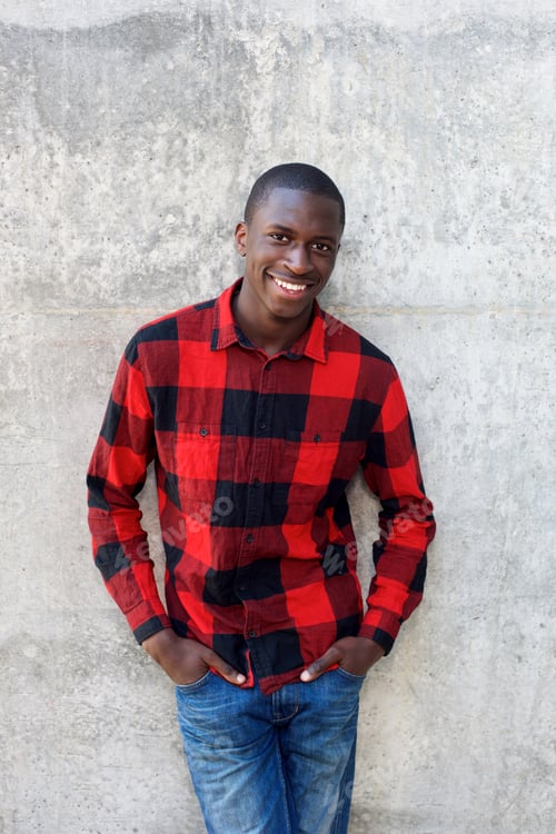 Preview: Handsome young male model posing against wall