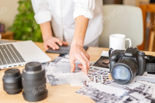Preview: Photographer reviewing images on desk with camera gear