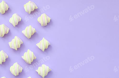 Preview: Colorful marshmallow laid out on violet paper background. pastel creative te