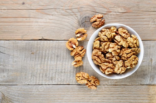Preview: Walnuts in bowl on wooden table top view