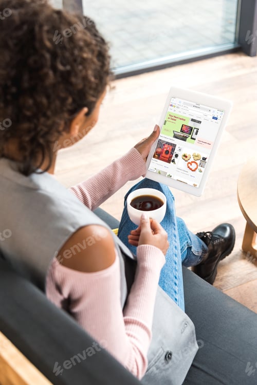 Preview: beautiful young woman using tablet with ebay website on screen