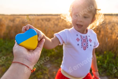 Preview: Child in a field of wheat with the flag of Ukraine. Selective focus.