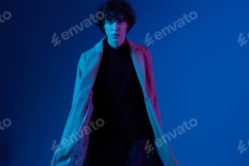 Preview: Man in fashion coat on dark blue background, neon light, style and trends, mixed light, men's