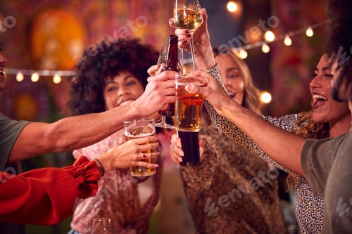 Preview: Multi-Cultural Group Of Friends Enjoying Night Out Drinking In Bar Together Making A Toast