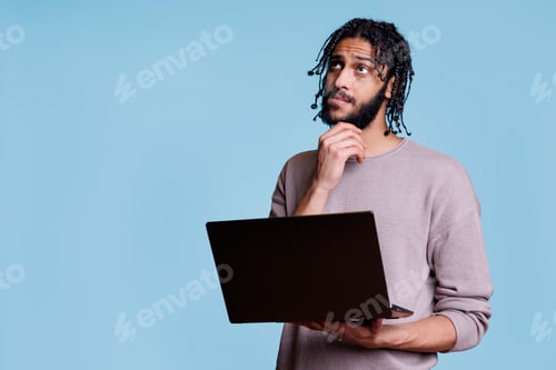 Preview: Arab man reading programming report on laptop