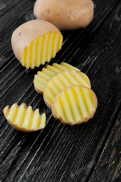 Preview: side view of cut and sliced potato on wooden background with copy space