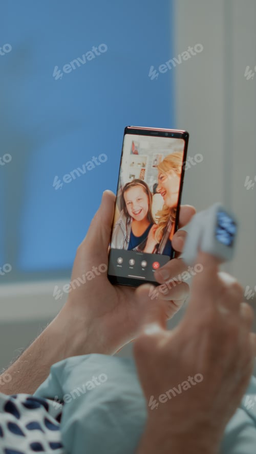 Preview: Sick elder patient talking on videocall with family in hospital ward