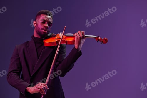 Preview: Elegant musician in black suit playing violin on a vibrant purple background for musical concept