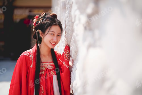 Preview: Young woman in traditional clothing smiling in a serene garden setting during daytime