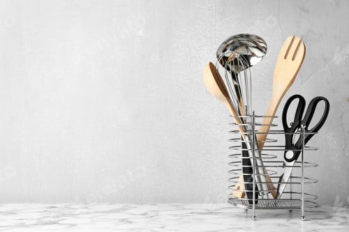Preview: Different kitchen utensils on table against light background. Space for text