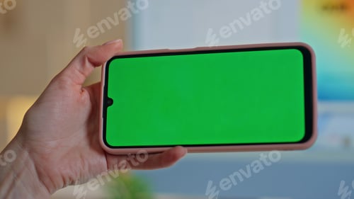 Preview: Student watching video chroma key smartphone at home closeup. Girl hand holding