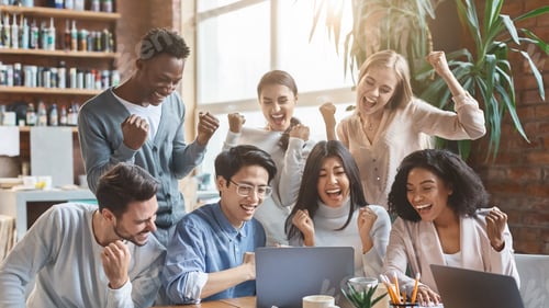 Preview: International business team looking at laptop screen, celebrating success