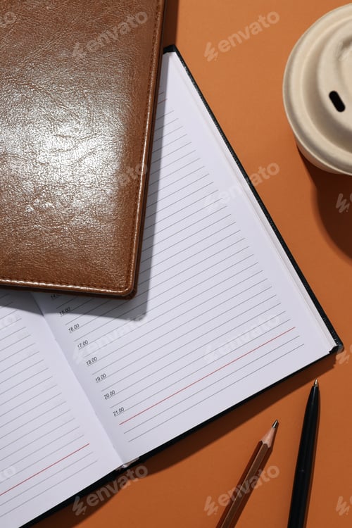 Preview: Black and brown notebooks with a cup of coffee