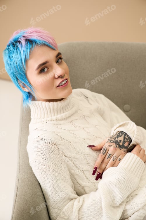 Preview: A young woman with colorful hair enjoys a peaceful moment while dressed in a cozy winter sweater