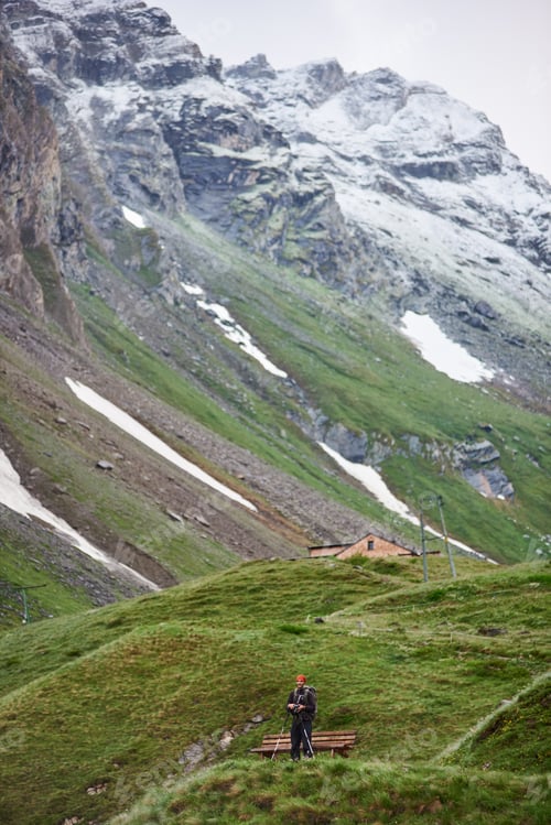 Preview: Traveler standing by the bench in mountain valley.