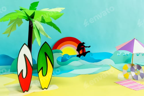 Preview: Creative papercraft of a beach, surfboards and a surfer silhouette on the waves