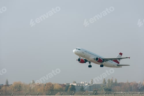 Preview: Commercial plane departure on airport airfield with cloudy sky at background
