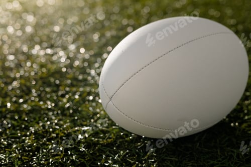 Preview: White rugby ball over grass with copy space, in slow motion