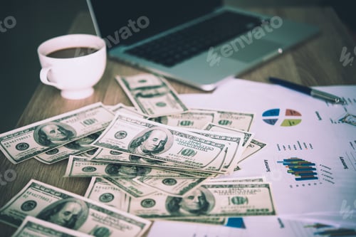 Preview: Working place of trader. The table covered by cash notes, keyboard and financial charts.